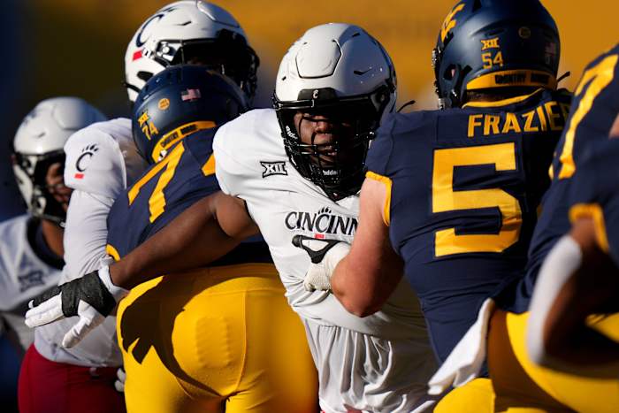 Cincinnati Bearcats defensive lineman Dontay Corleone (2) rushes the quarterback as West Virginia Mountaineers offensive lineman Zach Frazier (54) blocks in the first quarter during an NCAA college football game between the Cincinnati Bearcats and the West Virginia Mountaineers, Saturday, Nov. 18, 2023, at Milan Puskar Stadium in Morgantown, W. Va.  